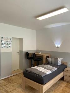 a bedroom with a bed and a desk and a table at Ferienwohnung H&M Immobilien Hettstedt 2 in Hettstedt