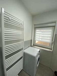 a bathroom with a washing machine and a window at Ferienwohnung H&M Immobilien Hettstedt 2 in Hettstedt