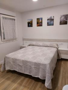 um quarto com uma cama e pinturas na parede em Casa Korrontxas & Ega Txokoa em Murieta