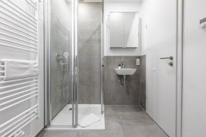 uma casa de banho com um chuveiro e um lavatório. em Diana Boardinghouse KONTAKTLOSER SELF CHECK IN & SELF CHECK OUT em Erzhausen
