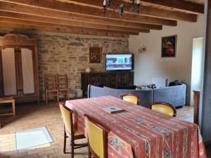 comedor con mesa, sillas y sofá en Longère près de Rocamadour et Padirac, en Alvignac