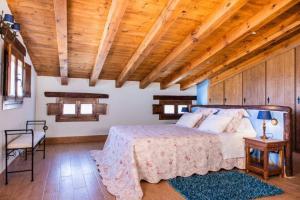 1 dormitorio con cama y techo de madera en Casa Rural LA LAVANDA Lugar de ensueño en la Alcarria en El Olivar