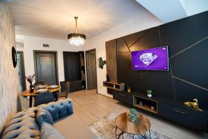 a living room with a couch and a tv on a wall at UpTown Apartments in Iaşi +104 photos