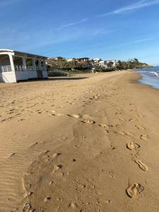 a couple of footprints in the sand on a beach at Appartamento con terrazzo sul mare. in Capo Rizzuto