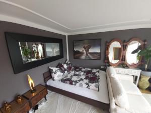 a bedroom with a bed and two mirrors at Penthouse with beautiful 360 terrace in Schaan