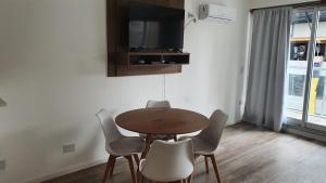 uma mesa e cadeiras num quarto com uma televisão em Nuevo y luminoso departamento en Palermo em Buenos Aires