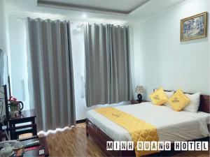 1 dormitorio con 1 cama con almohadas amarillas en Khách sạn Minh Quang en Phan Rang