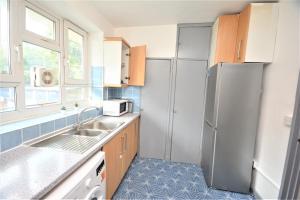 a kitchen with a refrigerator and a sink at Beautiful London 2 Bedroom Flat near Finsbury Park in London