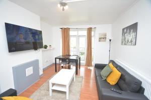 uma sala de estar com um sofá e uma mesa em Beautiful London 2 Bedroom Flat near Finsbury Park em Londres