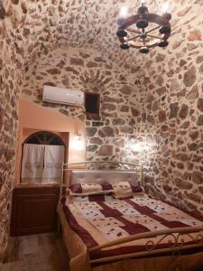 1 dormitorio con 1 cama y pared de piedra en Lithokastro, en Líthion