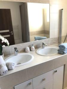 baño con 2 lavabos y espejo grande en maison cosy climatisée avec piscine et jardin en Calenzana