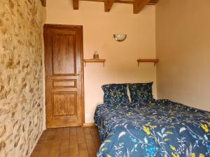 AlvignacLongère près de Rocamadour et Padirac的一间卧室配有一张床和一扇木门