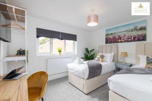 a bedroom with two beds and a desk with a laptop at 3Bed 2Bath House Contractors Accommodation free Parking WiFi Stevenage Hertfordshire Self Catering Sleeps 6 Guests By White Orchid Property Relocation in Stevenage