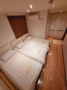 Cama blanca grande en habitación con suelo de madera en Moon Sun Guesthouse, en Seúl