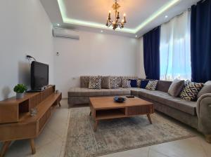 a living room with a couch and a tv at Villa Bleue plage Sonia in Zarzis