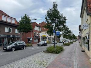 Una calle de la ciudad con coches aparcados en la calle. en Neubau Wohnung am Eversten Holz, en Oldenburg
