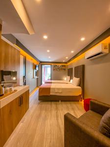 um quarto de hotel com uma cama e um sofá em L'opera Deluxe Hotel em Akçay