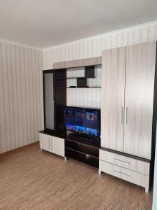 a living room with a flat screen tv on a entertainment center at Стандарт апартаменты ул.Урицкого 74 in Pavlodar