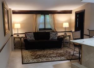 a living room with a black couch and two lamps at Chalet Inn & Suites in Centerport