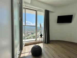 sala de estar con ventana grande con vistas en MERDZ Spa & Fitness Sky Apartment en Skopje