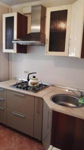 uma cozinha com um lavatório e um fogão forno superior em 1 комн квартира в центре em Qostanay