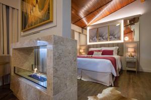 a bedroom with a large bed and a fireplace at Blumen Hotel Boutique in Canela