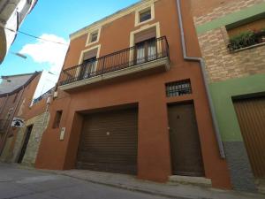 un edificio con due porte garage e un balcone di Cal Magí a Sant Martí de Maldá
