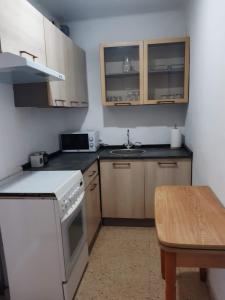 a small kitchen with white appliances and a table at Apartamentos Can bruguera 3 in Mataró