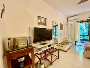 a living room with a large flat screen tv at Housing 31 - Cond. Mata Azul - frente á entrada 18 in São Sebastião