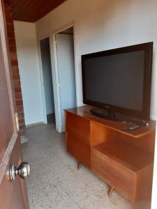a flat screen tv sitting on top of a wooden entertainment center at Apartamentos Can bruguera 3 in Mataró