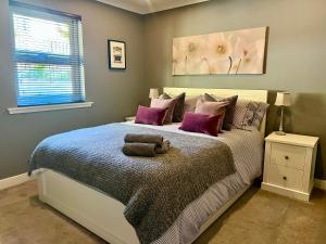 een slaapkamer met een groot bed met paarse kussens bij Holly Lodge - Luxury Two Kingsize bedrooms with private entrance - entire place in Oban