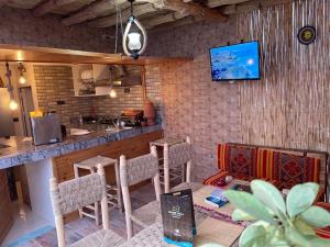 a kitchen with a bar and a tv on the wall at House Viola in Imsouane