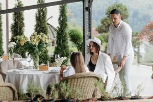 Ein Mann und eine Frau sitzen an einem Tisch in der Unterkunft Ведмежа гора Panorama Spa Resort in Jaremtsche