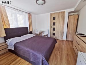 米兹多洛杰Villa Krysia 50 m do morza的一间卧室，配有一张床和一张桌子和椅子