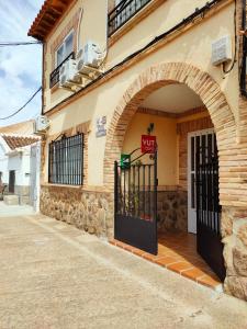 een toegang tot een gebouw met een boogdeur bij Casa Rosales Toledo a 10 minutos de Puy du Fou in Polán