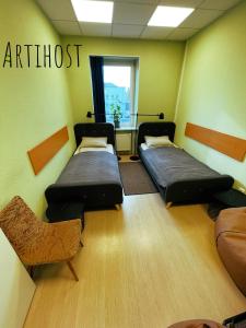 a room with two beds and a couch and a window at Artihost in Panevėžys