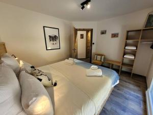 1 dormitorio con 1 cama grande y toallas. en La cabane des écureuils, en Xonrupt-Longemer