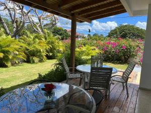un patio con 2 mesas, sillas y flores en Villa del Carmen Boqueron en Cabo Rojo