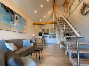 een woonkamer met een bank en een trap bij Penthouse 7 Heaven Nordsee Park Dangast in Dangast