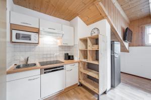 a kitchen with white appliances and wooden ceilings at Apart Holiday in Sölden