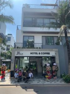 un hôtel et un café avec des personnes assises à l'extérieur dans l'établissement Joy Villa Flamingo Đại Lải - 5 phòng ngủ, à Phúc Yên