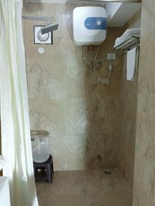 a bathroom with a shower and a sink and a toilet at Hotel Zingkham Residency in Gangtok