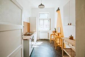 cocina con armarios blancos, fregadero y mesa en Central Design-Apartment next to Belvedere Castle en Viena