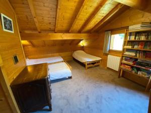 an attic room with two beds and a book shelf at Chalet individuel avec cheminée et garage, 10 pers, La Clusaz - FR-1-459-2 in La Clusaz