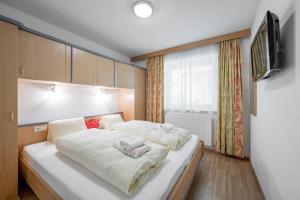 a bedroom with a large bed with white sheets at Apart Holiday in Sölden