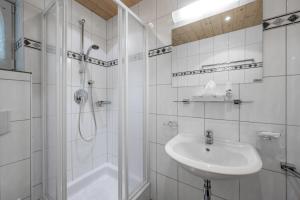 a white bathroom with a sink and a shower at Apart Holiday in Sölden