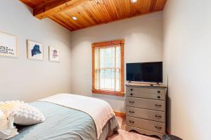 a bedroom with a bed and a flat screen tv at Sunset Lodge in Kingfield