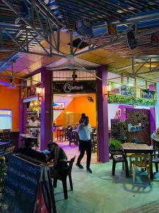 a group of people walking through a restaurant at Tambo Hostel in Leticia