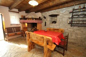 comedor con mesa roja y pared de piedra en Holiday house with a parking space Celici, Central Istria - Sredisnja Istra - 7333 en Barban