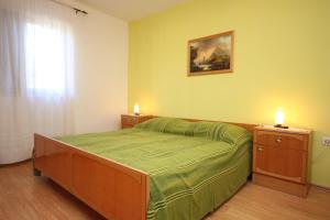 a bedroom with a bed and two candles on tables at Holiday house with a parking space Presika, Labin - 7391 in Labin